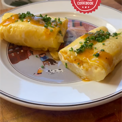 Image of an omelette with chives, cheese and hot sauce