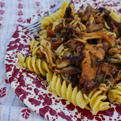 a plate of pasta with mushrooms and thyme