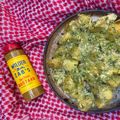 A bowl of Potato Salad next to a bottle of Zab