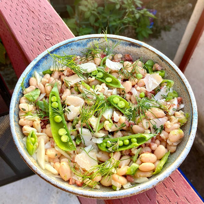 Bowl of salad with beans, peas, herbs and pancetta.  